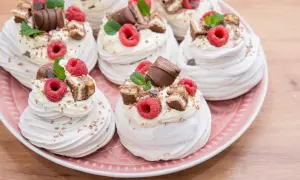 Mini pavlova z bitą śmietaną, malinami i kawałkami czekolady. Idealne na deser.