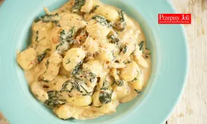Pyszne gnocchi z kurczakiem w kremowym sosie ze szpinakiem, posypane parmezanem. Idealne danie na szybki obiad.