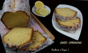 Pyszne ciasto cytrynowe z lukrem, pokrojone na kawałki, obok plasterki cytryny.