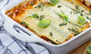 Pyszne lasagne ze szpinakiem i cukinią, zapieczone pod warstwą sera, ozdobione bazylią i tymiankiem.
