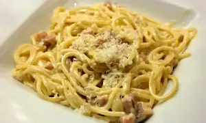 Pyszna carbonara z kawałkami guanciale i startym parmezanem. Idealny ser do carbonary to klucz do sukcesu.