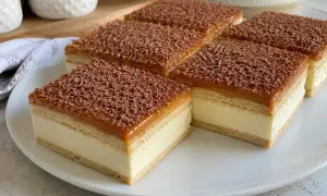 Pyszne ciasto krówka z kremem i karmelem, posypane czekoladą. Idealne na deser.