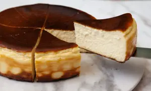 Kawałek pysznego, lekko przypieczonego basque cheesecake jest wyjmowany z całego ciasta.