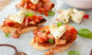 Pyszna bruschetta przepis: chrupiące grzanki z pomidorami, bazylią i mozzarellą w kształcie serc. Idealna na romantyczną kolację.