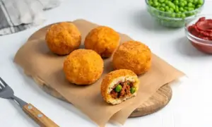 Arancini co to? Złociste kulki ryżowe z mięsem i groszkiem, chrupiące na zewnątrz, soczyste w środku. Idealna przekąska.