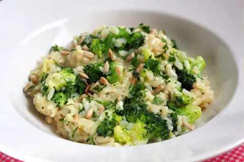 Kremowe risotto z brokułami, posypane słonecznikiem i natką pietruszki. Pyszne i zdrowe danie.