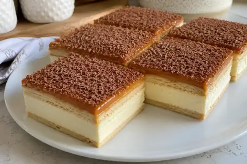 Pyszne ciasto krówka z kremem i karmelem, posypane czekoladą. Idealne na deser.