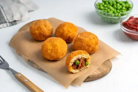 Arancini co to? Złociste kulki ryżowe z mięsem i groszkiem, chrupiące na zewnątrz, soczyste w środku. Idealna przekąska.