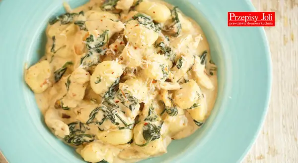 Pyszne gnocchi z kurczakiem w kremowym sosie ze szpinakiem, posypane parmezanem. Idealne danie na szybki obiad.