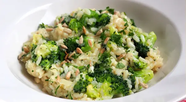 Kremowe risotto z brokułami, posypane słonecznikiem i natką pietruszki. Pyszne i zdrowe danie.