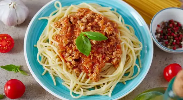 Pyszne spaghetti bolognese, prosty przepis na szybki obiad. Aromatyczny sos mięsny z bazylią na złocistym makaronie.