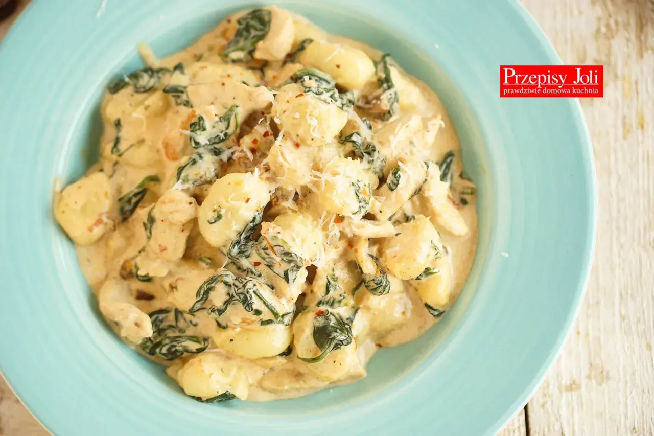 Pyszne gnocchi z kurczakiem w kremowym sosie ze szpinakiem, posypane parmezanem. Idealne danie na szybki obiad.