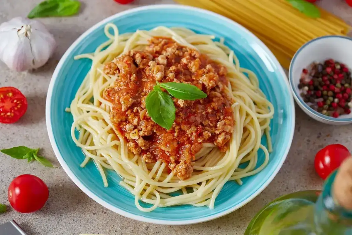Pyszne spaghetti bolognese, prosty przepis na szybki obiad. Aromatyczny sos mięsny z bazylią na złocistym makaronie.