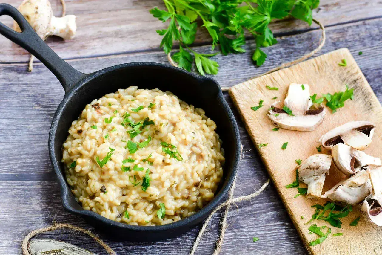 Kremowe risotto z grzybami, posypane natką pietruszki. Idealny przepis na risotto, który zachwyci każdego.