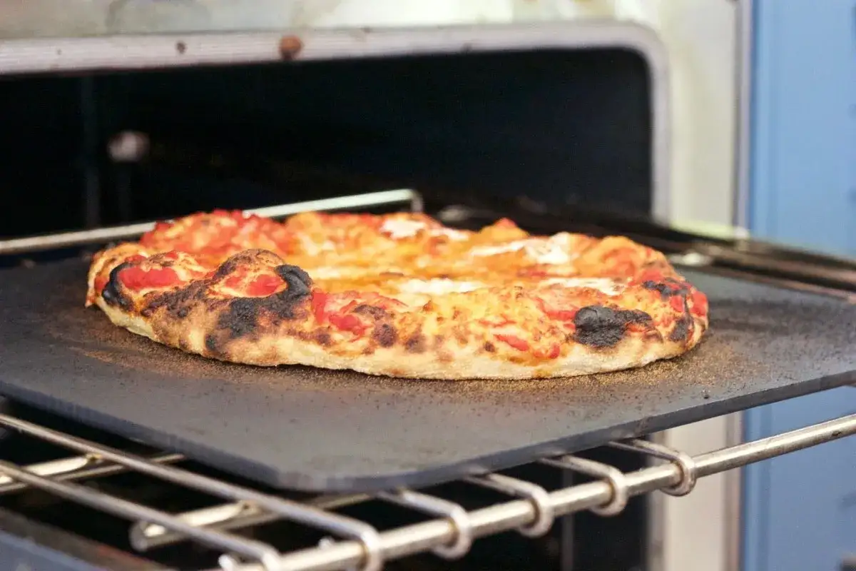 Pizza na kamieniu w piekarniku, idealnie wypieczona. W jakiej temperaturze piec pizzę, by uzyskać taki efekt?