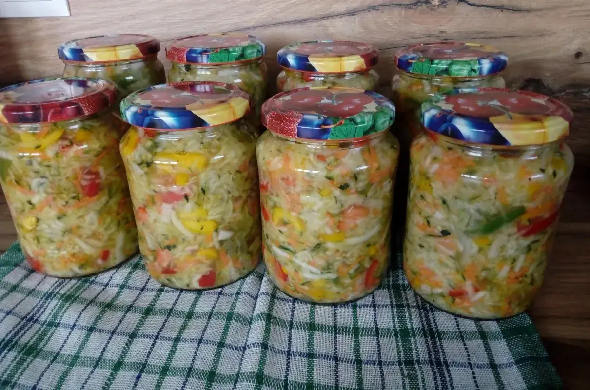 Słoiki z domową sałatką z cukinii, marchewki i papryki, gotowe na zimę.
