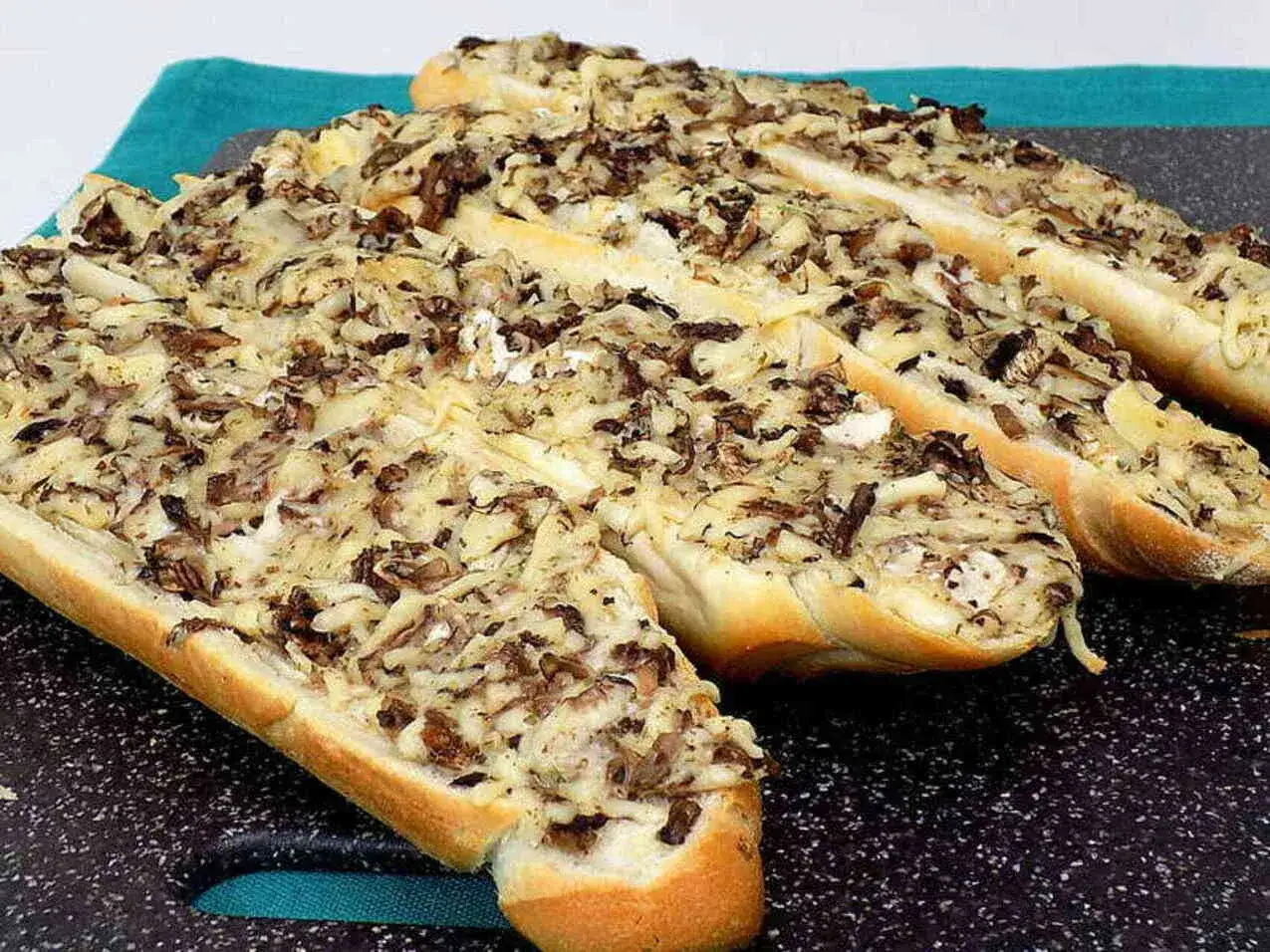 Pyszna zapiekanka z pieczarkami i serem, podana na chrupiącej bagietce. Idealna na szybką przekąskę.