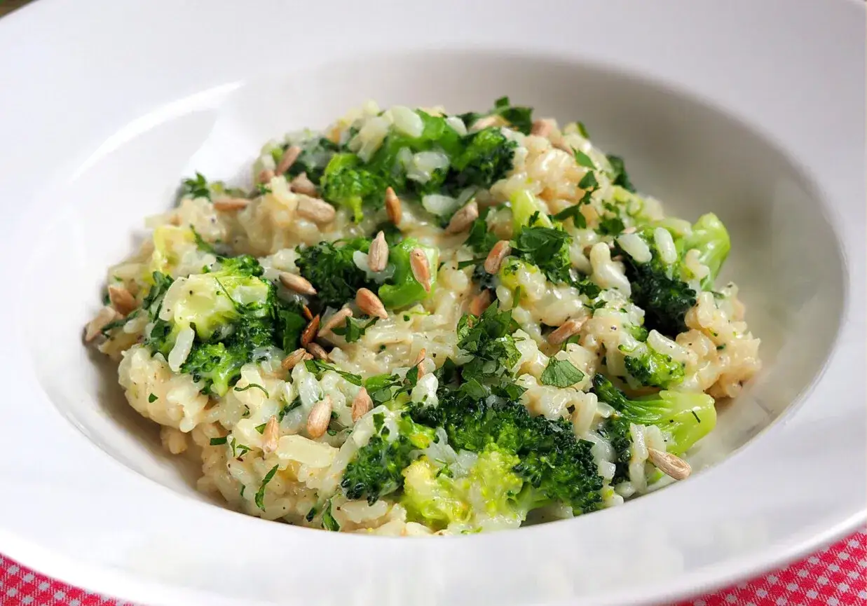 Kremowe risotto z brokułami, posypane słonecznikiem i natką pietruszki. Pyszne i zdrowe danie.
