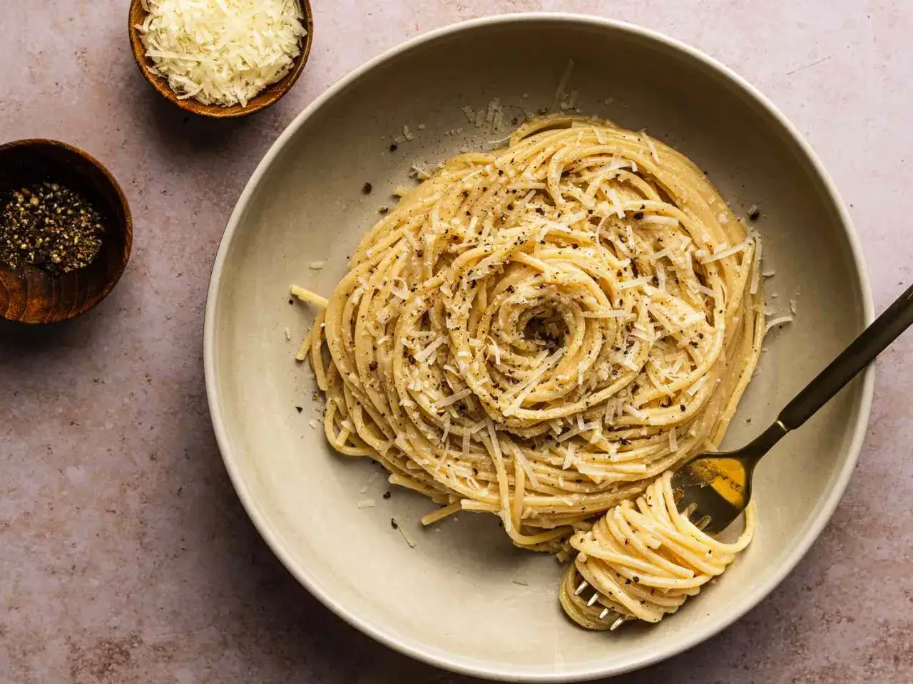 Pyszne spaghetti cacio e pepe, posypane parmezanem i świeżo mielonym pieprzem. Idealny przepis na szybki obiad.
