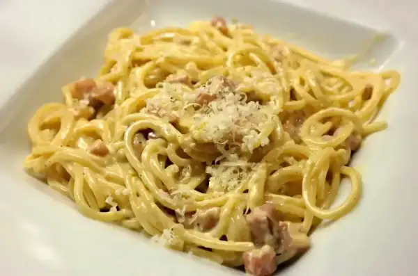 Pyszna carbonara z kawałkami guanciale i startym parmezanem. Idealny ser do carbonary to klucz do sukcesu.