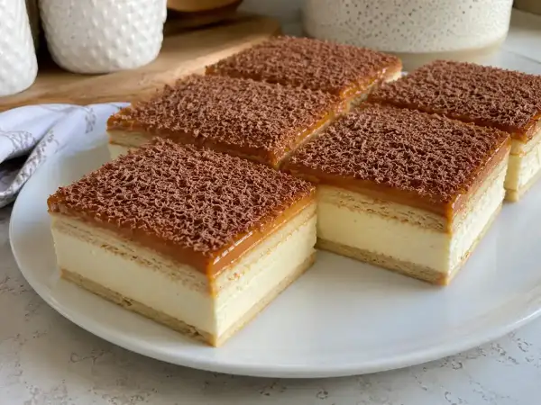 Pyszne ciasto krówka z kremem i karmelem, posypane czekoladą. Idealne na deser.